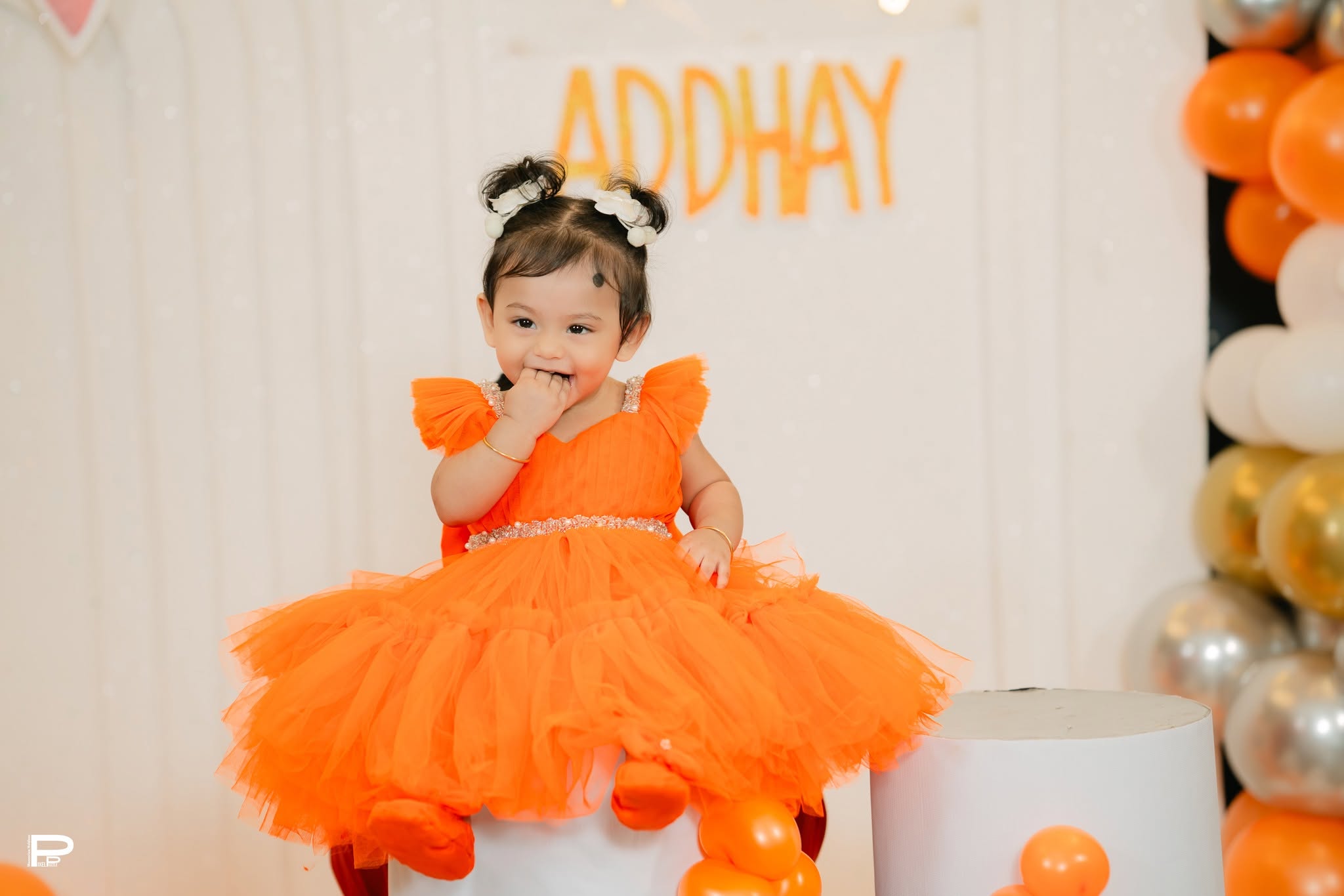 Child in an orange birthday dress at a PixelPuzzle celebration